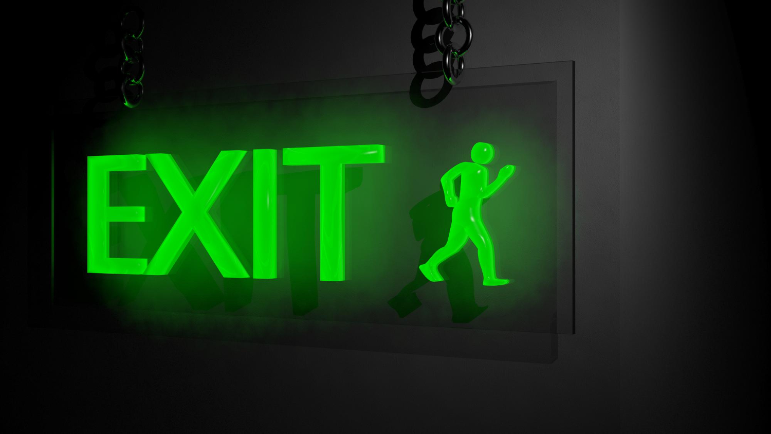 exit lights Illuminated green exit sign with a running figure, hung on a wall.